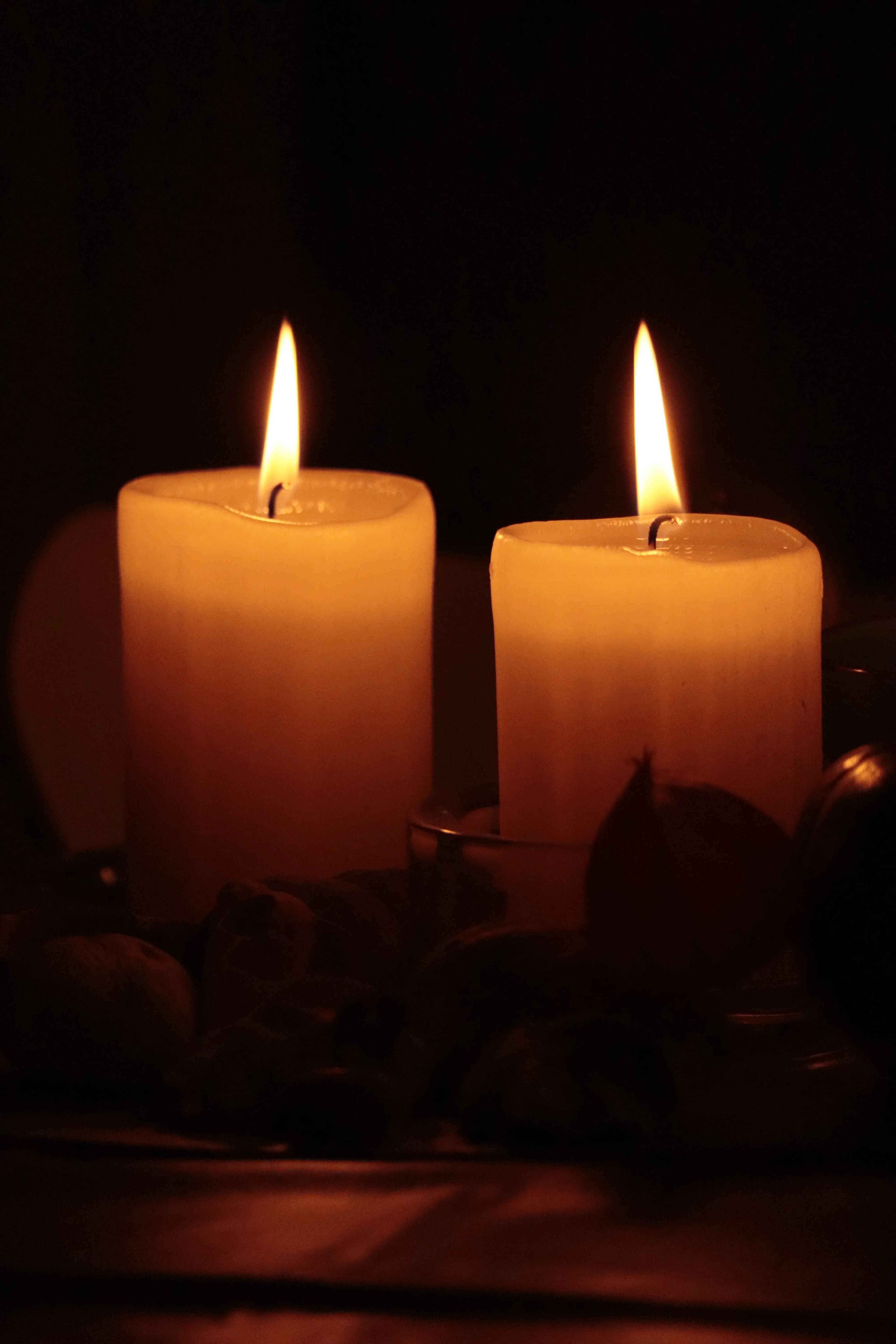 Dos velas encendidas en la penumbra durante un ritual